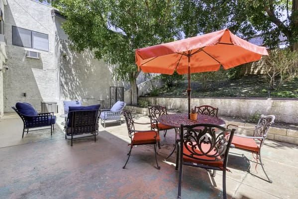 Outdoor seating area with a red umbrella and chairs