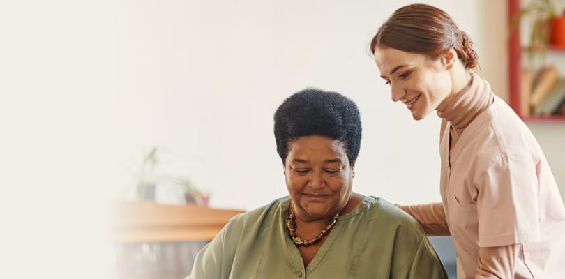 Staff member assisting a resident in a warm environment