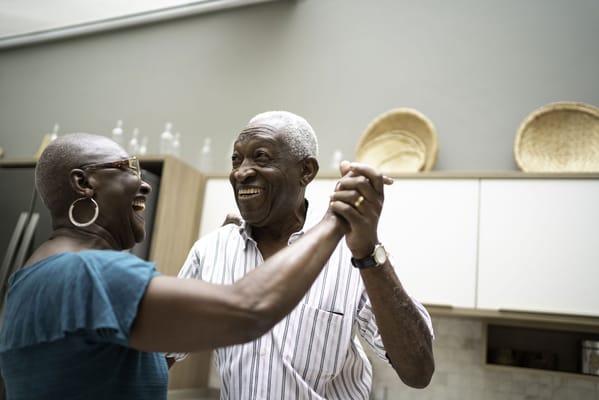 Elderly couple dancing and enjoying in a kitchen