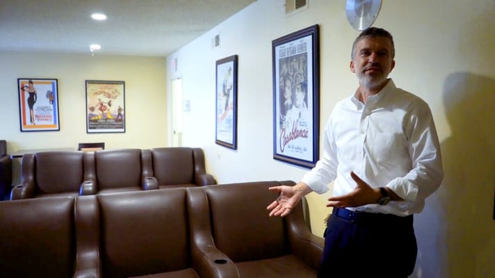 Man explaining in a comfortable lounge area with posters