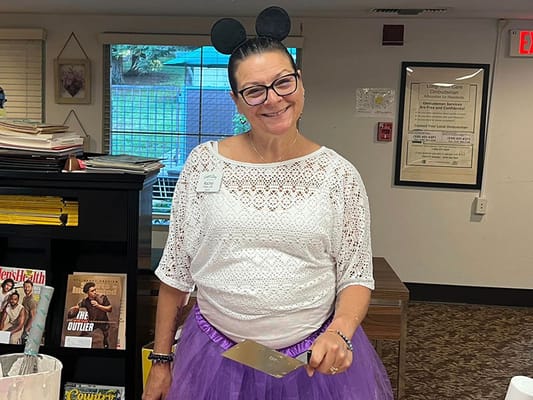 Staff member in costume with a spatula in a common area