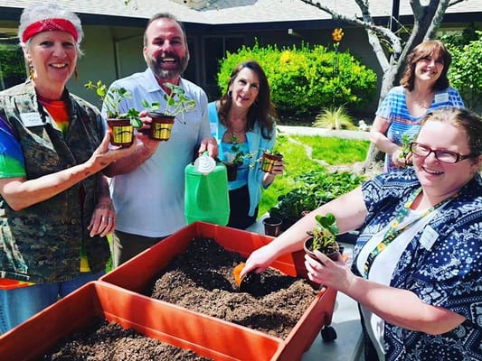 Residents and staff gardening together outside