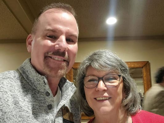 Two smiling people posing together in a social setting