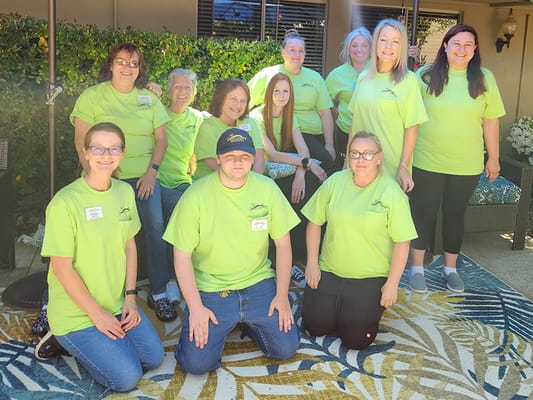 Staff members posing outside in matching shirts
