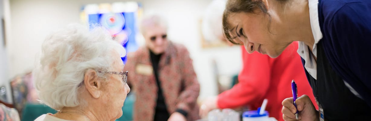 Care staff assisting a resident in a common area