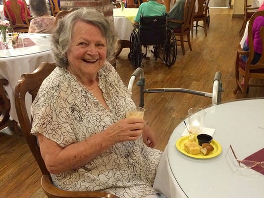 Resident enjoying food and drink in the dining area