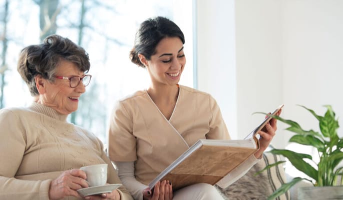 Caregiver reading with a resident in a cozy indoor setting