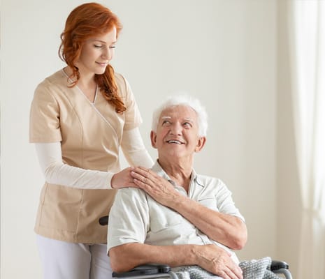 Care staff assisting a resident in a well-lit room