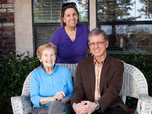Residents and staff smiling together outdoors