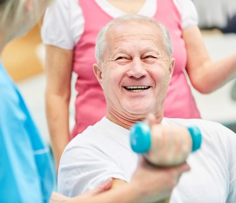 Resident participating in a fitness activity with staff support