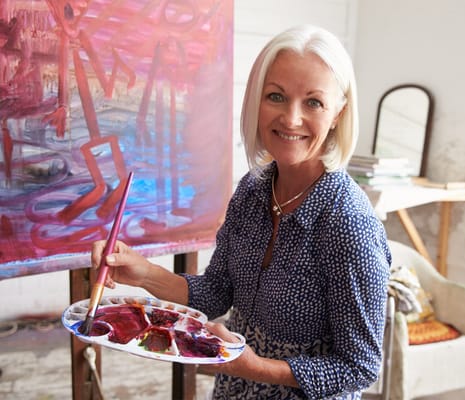 Senior resident painting in an activity room