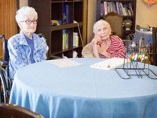 Two residents playing bingo in a common area