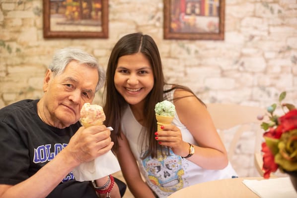 Resident and guest enjoying ice cream in a dining area