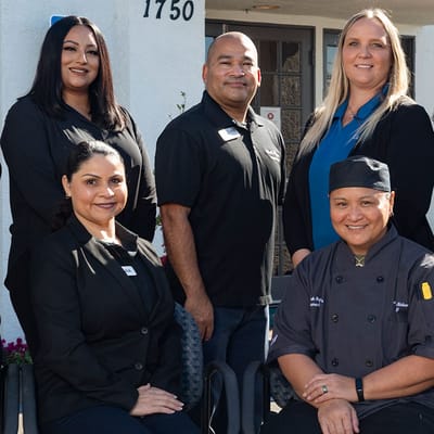 Staff members posing in front of the facility entrance