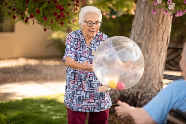 Senior resident playing with a beach ball outdoors