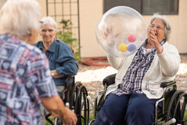 Residents enjoying an outdoor activity with colorful balls.