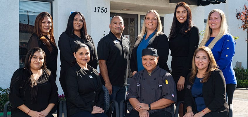 Staff members posing outside the facility entrance