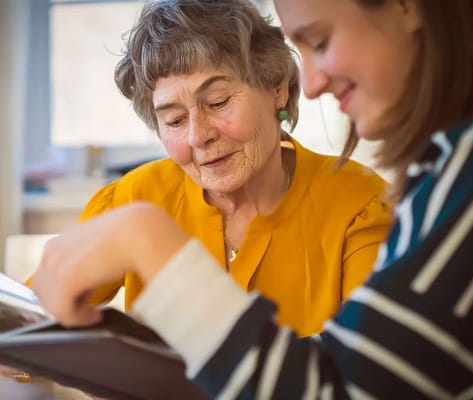Two women looking at a photo album together