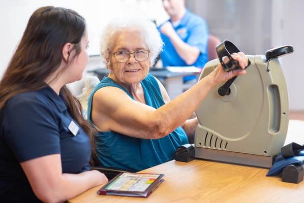 Resident exercising with staff assistance in therapy session