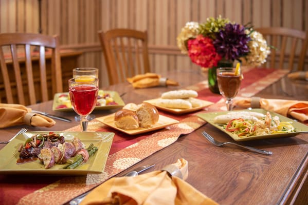 A beautifully set dining table with meals and drinks.