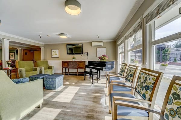 Bright common area with seating and a piano