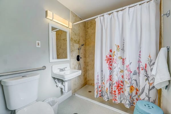 A clean bathroom with floral shower curtain