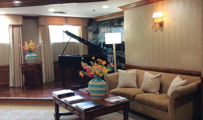 Cozy common area with piano and floral arrangements