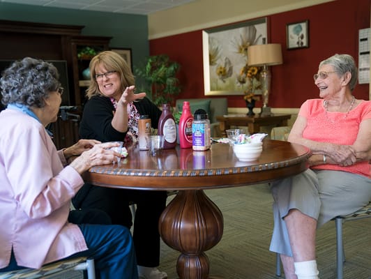 Residents enjoying conversation at a table in a common area