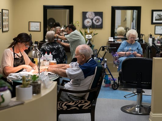 Residents enjoying hair salon services in a cozy setting