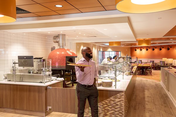 Staff member serving food in the dining room