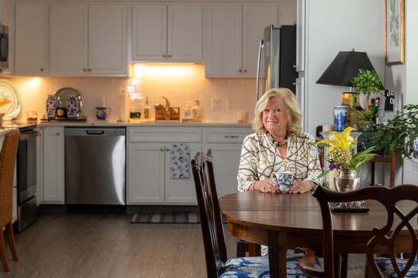 A resident enjoying tea at a dining table in a modern kitchen.