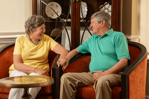 Two smiling residents enjoying conversation in a cozy setting