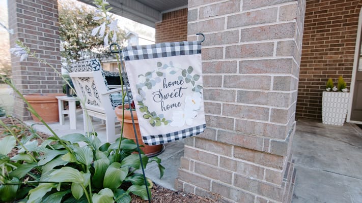Garden flag with 'home sweet home' in a welcoming entrance
