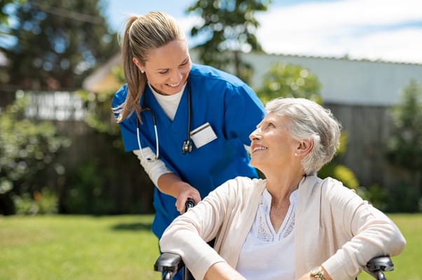 Nurse assisting senior woman in a garden