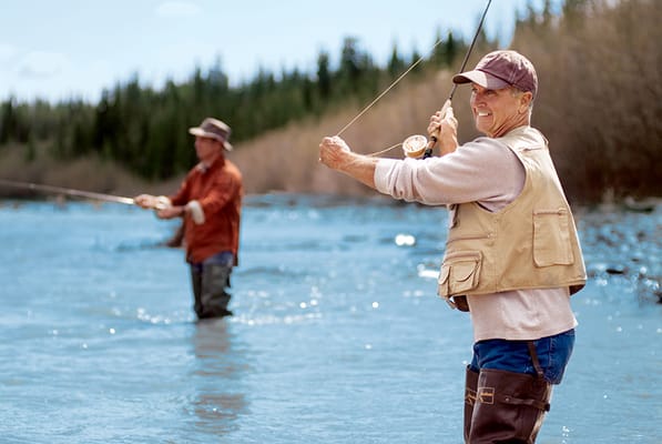 Two seniors fishing in a serene outdoor setting