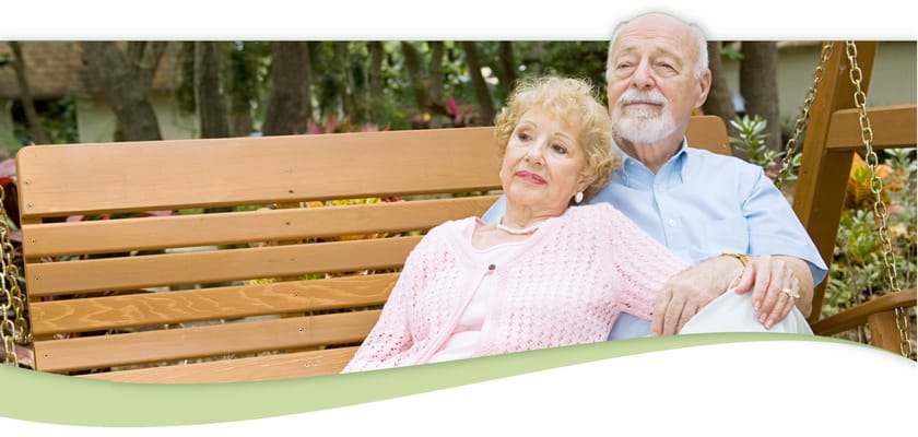A couple relaxing on a swing in a garden setting