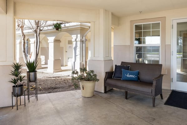 A cozy seating area with plants and a welcome sign