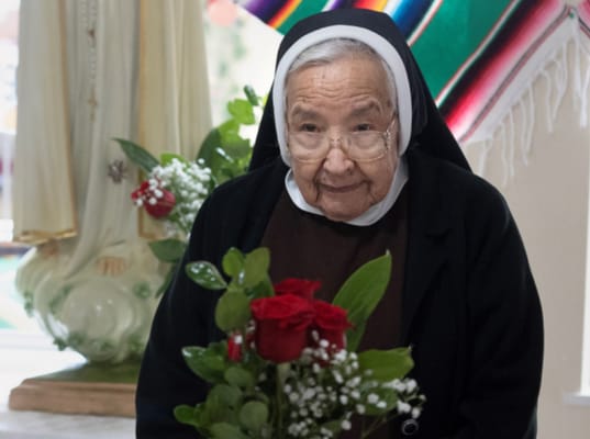 Senior resident holding a bouquet of flowers