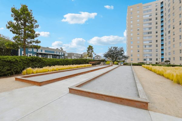 Outdoor space with bocce ball court and apartment building