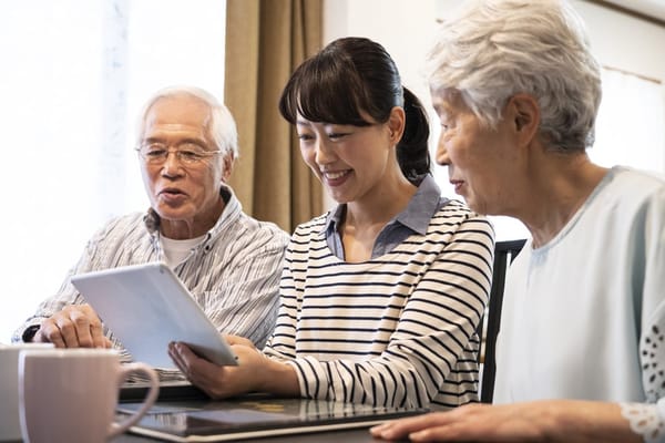 Three individuals engaged in a discussion around a tablet
