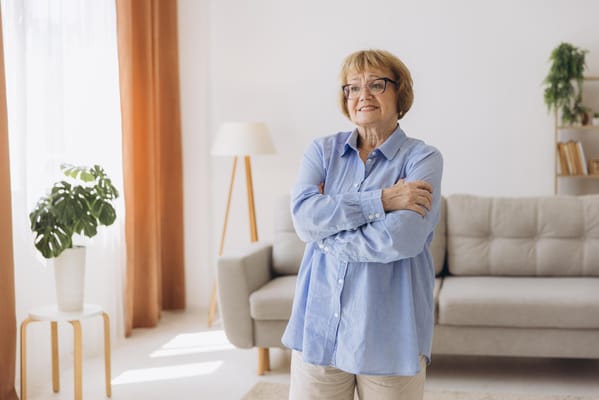 A smiling elderly woman in a cozy living room