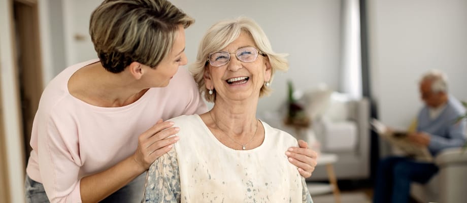 A caregiver and resident sharing a joyful moment indoors