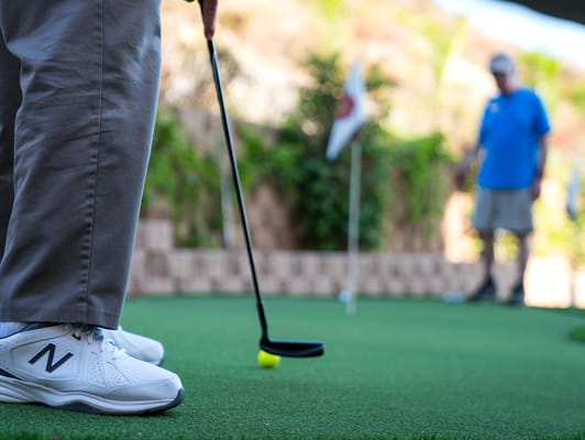 Two residents enjoying mini-golf activity outdoors