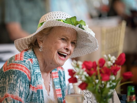 A joyful resident enjoying an event with flowers