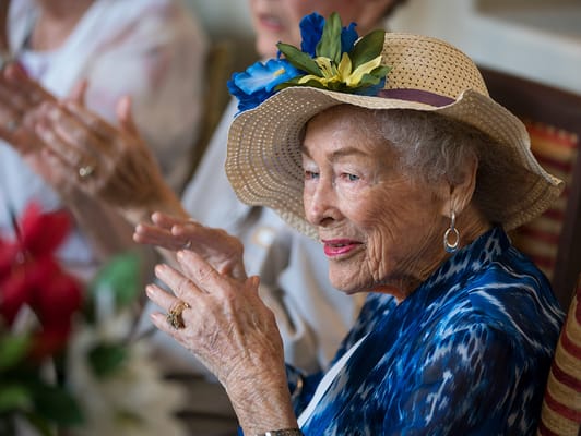 A joyful resident clapping during a celebration.