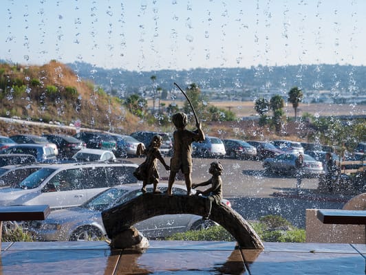 Sculpture of children in front of a water feature