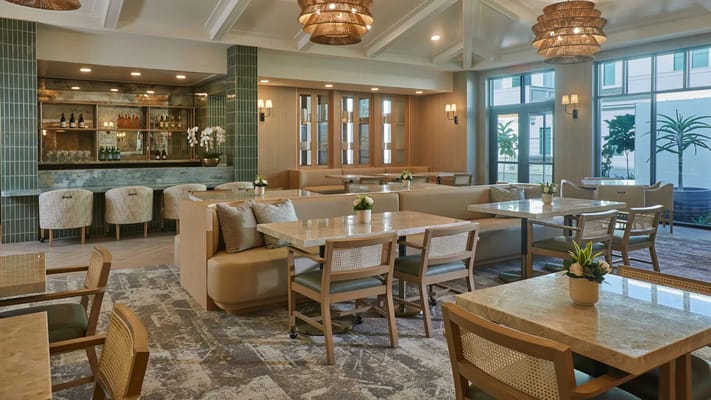 A stylish common area with dining tables and decor