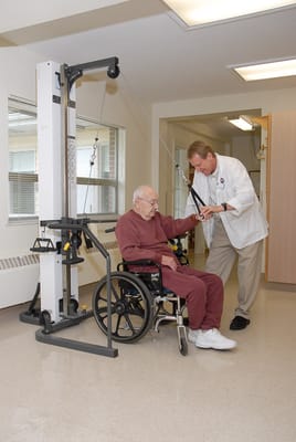 Therapist assisting a senior in a rehabilitation setting