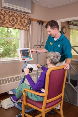 Staff assisting a resident with a therapy device