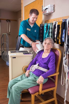Staff assisting a resident in a therapy setting